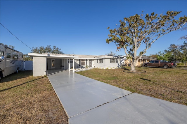 ranch-style house featuring a carport and a front lawn