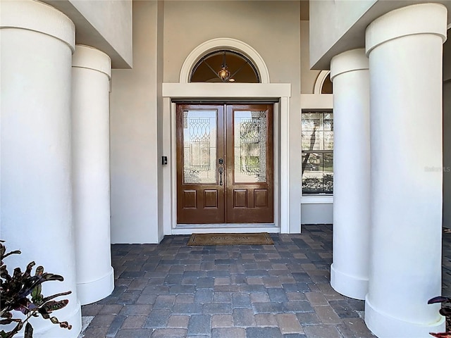 property entrance featuring stucco siding and french doors