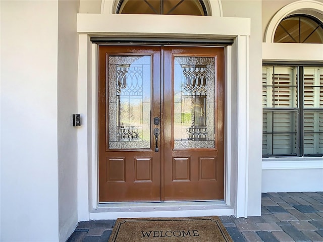 view of exterior entry with french doors and stucco siding