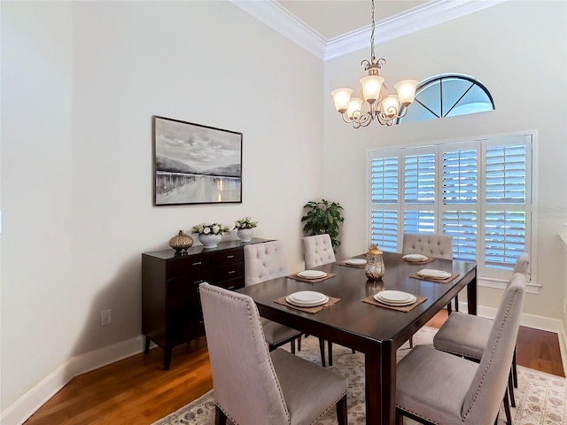 dining area featuring baseboards, ornamental molding, wood finished floors, and an inviting chandelier