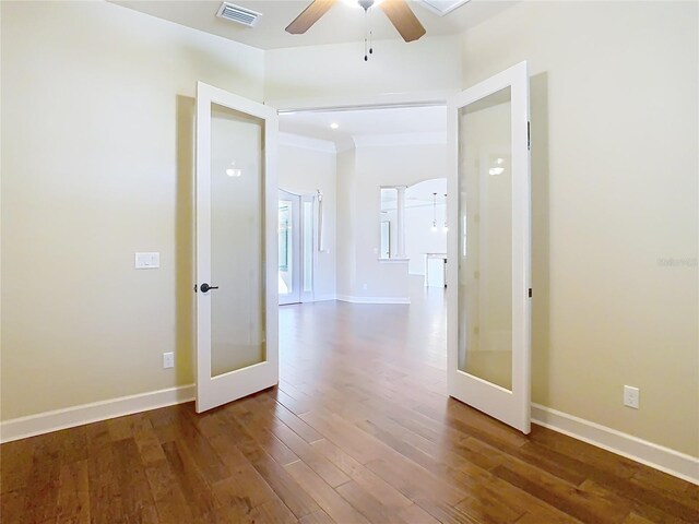 corridor featuring baseboards, visible vents, and wood finished floors