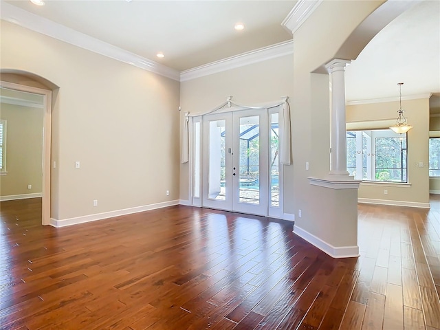 interior space with arched walkways, french doors, decorative columns, and wood finished floors