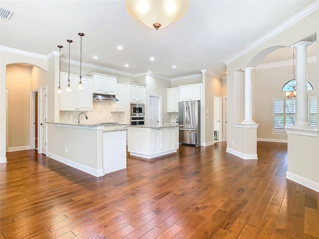 kitchen featuring under cabinet range hood, decorative columns, dark wood-style floors, and appliances with stainless steel finishes