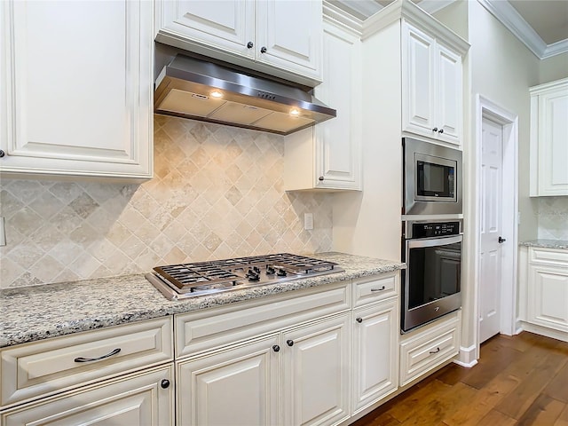 kitchen featuring dark wood-style floors, decorative backsplash, appliances with stainless steel finishes, ornamental molding, and under cabinet range hood