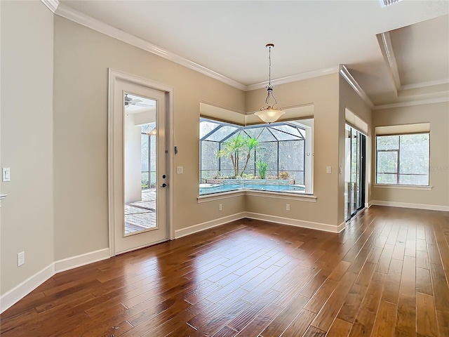 unfurnished dining area featuring ornamental molding, dark wood-type flooring, and baseboards