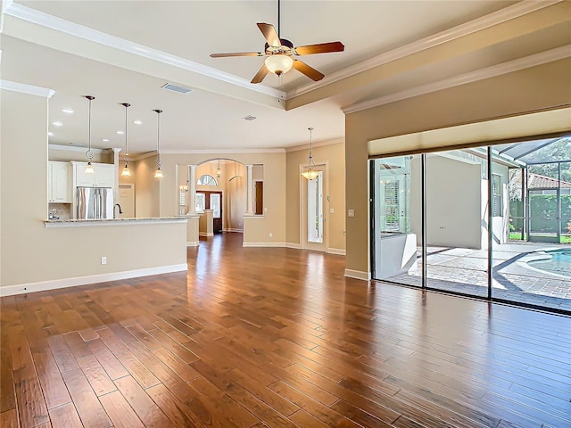 unfurnished living room with dark wood-style flooring, visible vents, a raised ceiling, and baseboards