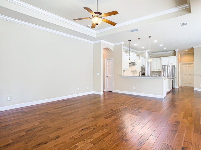 unfurnished living room featuring dark wood-style floors, arched walkways, visible vents, and ceiling fan