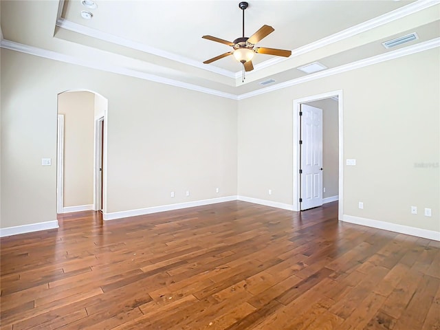 unfurnished room featuring arched walkways, a raised ceiling, visible vents, and hardwood / wood-style floors