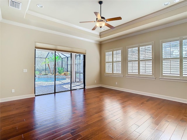 spare room with ornamental molding, visible vents, dark wood finished floors, and baseboards