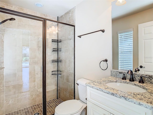 full bathroom with toilet, a shower stall, and vanity