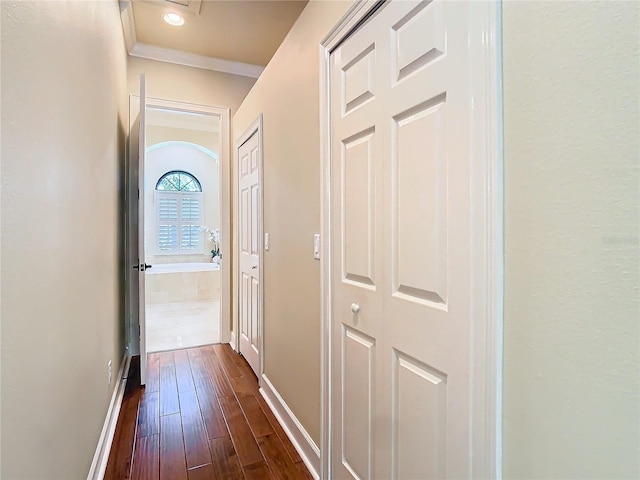 hallway with crown molding, dark wood finished floors, and baseboards