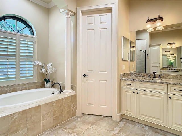 bathroom with a stall shower, decorative columns, vanity, and a bath