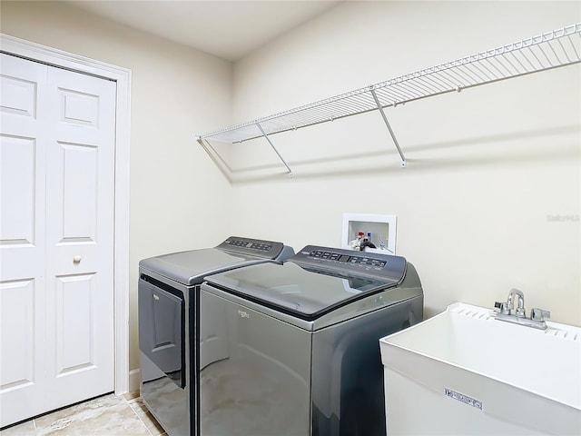 clothes washing area with laundry area, a sink, and independent washer and dryer