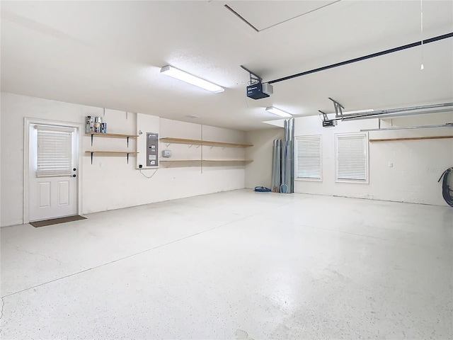 garage featuring electric panel and a garage door opener