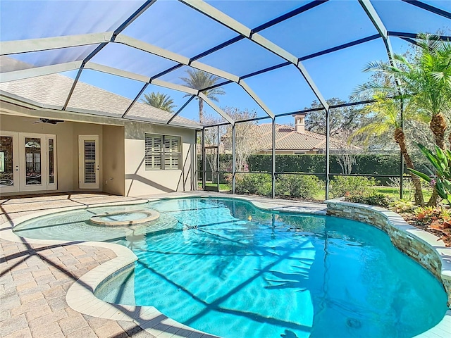 view of swimming pool featuring a ceiling fan, a lanai, french doors, a patio area, and a pool with connected hot tub