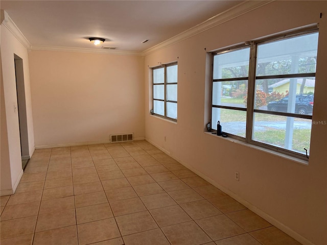 spare room with ornamental molding, light tile patterned floors, and plenty of natural light