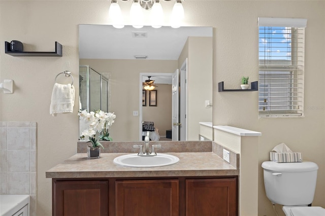 bathroom with ceiling fan, vanity, toilet, and walk in shower