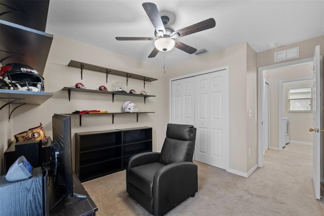 sitting room with ceiling fan and light carpet