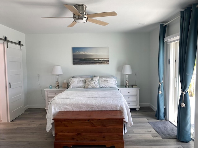 bedroom featuring ceiling fan, light hardwood / wood-style flooring, and a barn door