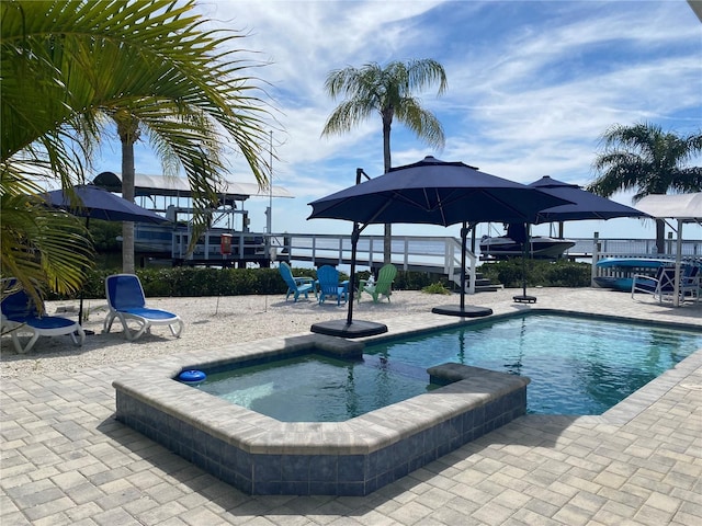 view of swimming pool with a water view, an in ground hot tub, and a patio area