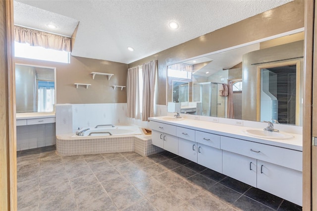 bathroom featuring vanity, shower with separate bathtub, and a textured ceiling