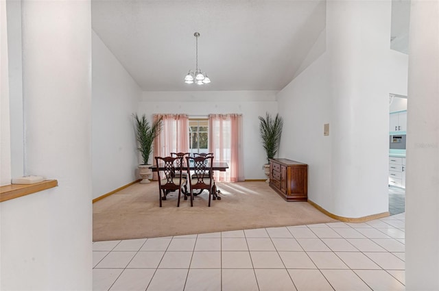 dining room featuring a notable chandelier, vaulted ceiling, and light colored carpet