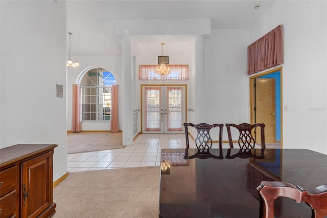 carpeted entryway featuring a notable chandelier and french doors