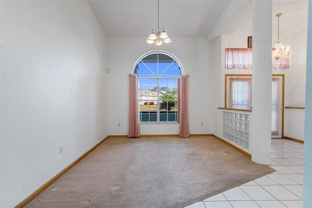 tiled spare room featuring an inviting chandelier and a high ceiling