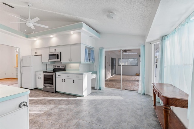 kitchen featuring vaulted ceiling, appliances with stainless steel finishes, white cabinets, backsplash, and ceiling fan