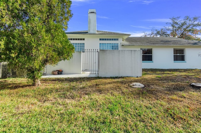 rear view of property with a yard