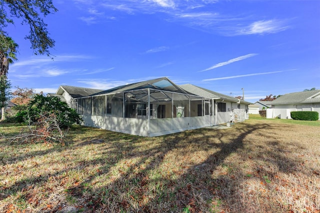 back of property with a yard and glass enclosure