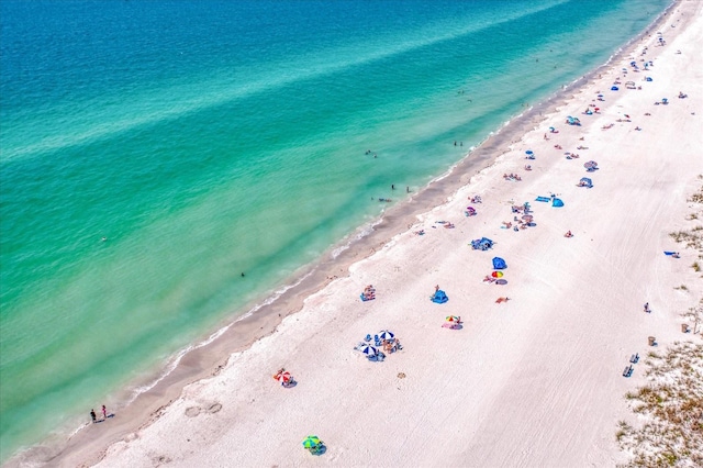 drone / aerial view featuring a water view and a view of the beach