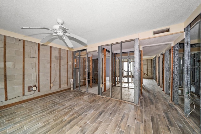 interior space with ceiling fan and a textured ceiling