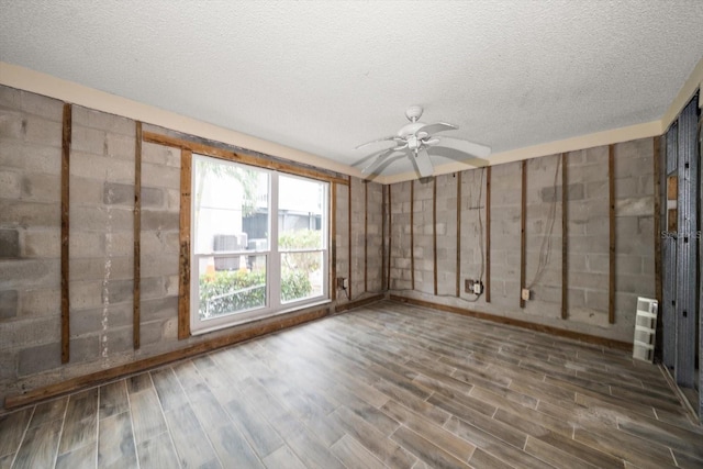 interior space with a textured ceiling, ceiling fan, and wood-type flooring