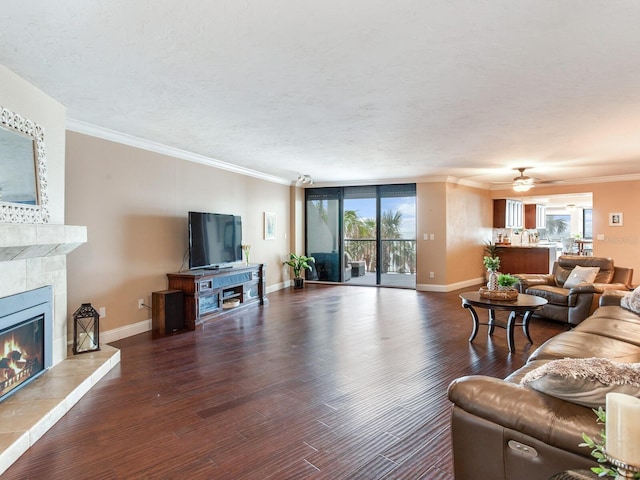 living room featuring ceiling fan, a tiled fireplace, floor to ceiling windows, and wood-type flooring