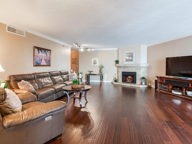 living room with dark hardwood / wood-style flooring, crown molding, and a fireplace