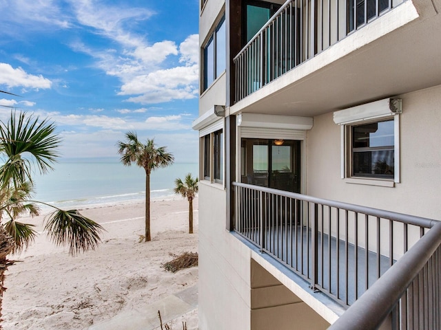 exterior space with a beach view, a balcony, and a water view