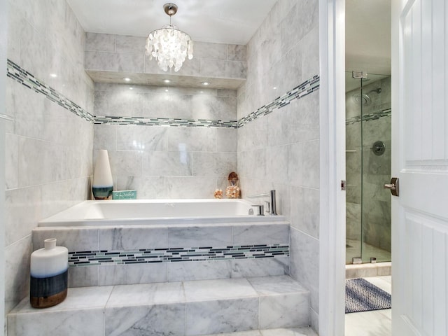 bathroom featuring an inviting chandelier, shower with separate bathtub, and tile walls