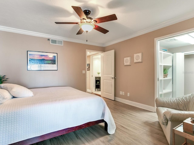 bedroom featuring ceiling fan, crown molding, and light hardwood / wood-style floors