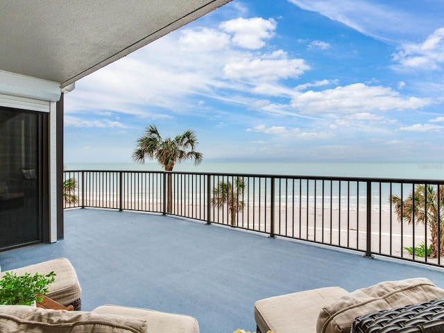 balcony featuring a water view and a beach view