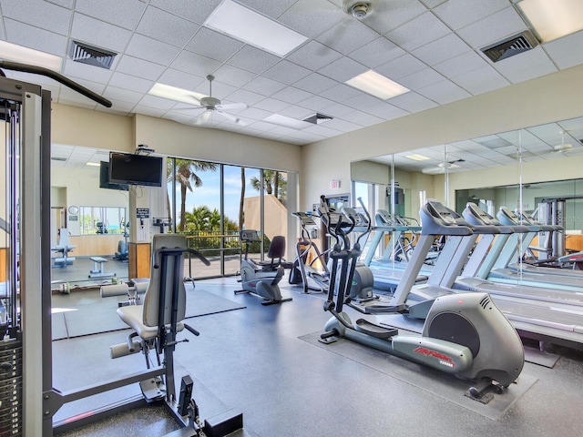 workout area featuring ceiling fan and a drop ceiling