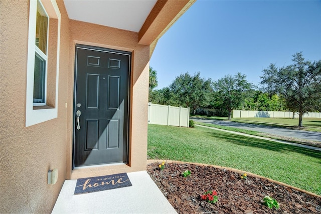 entrance to property with a lawn