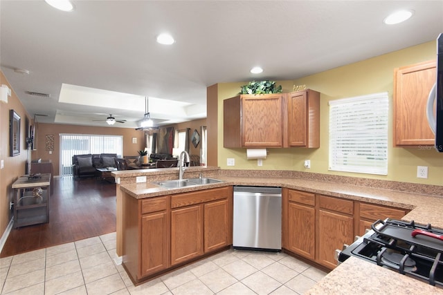 kitchen with sink, dishwasher, ceiling fan, light tile patterned floors, and kitchen peninsula