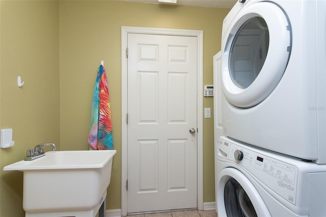 laundry area with sink, light tile patterned floors, and stacked washer / drying machine