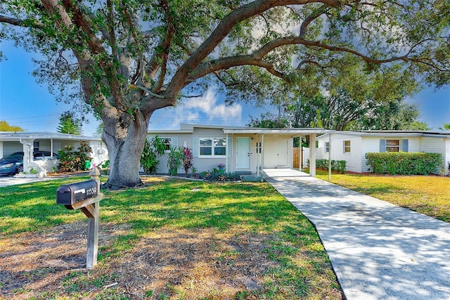 ranch-style house featuring a carport and a front lawn