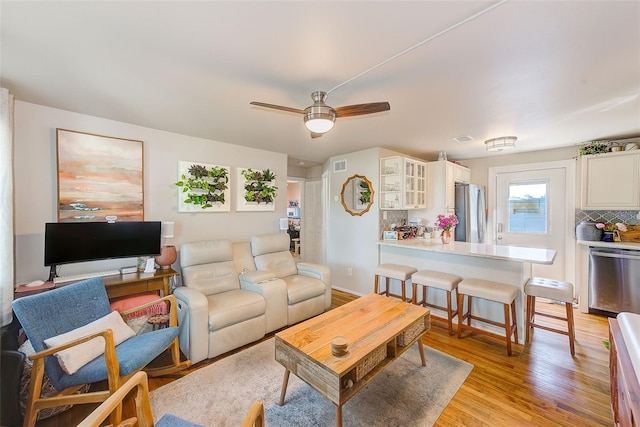 living room featuring light wood-type flooring and ceiling fan