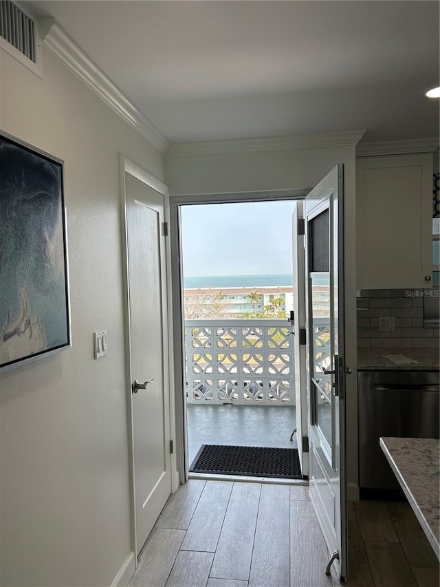 interior space with visible vents, crown molding, and wood finished floors