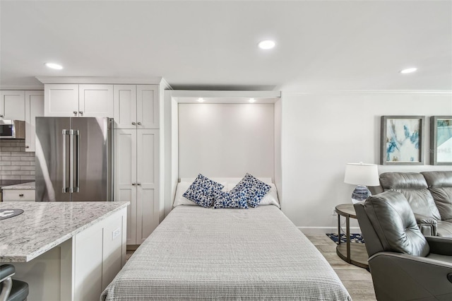 bedroom featuring baseboards, high end fridge, light wood-type flooring, and recessed lighting