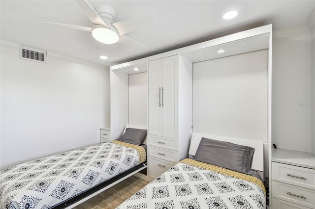 bedroom with recessed lighting, wood finished floors, visible vents, and crown molding