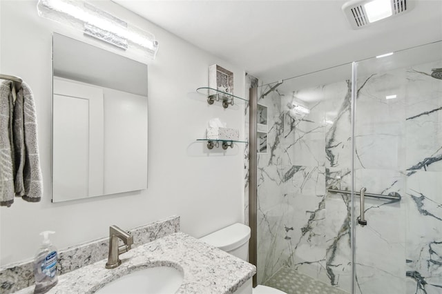 bathroom with a marble finish shower, visible vents, vanity, and toilet